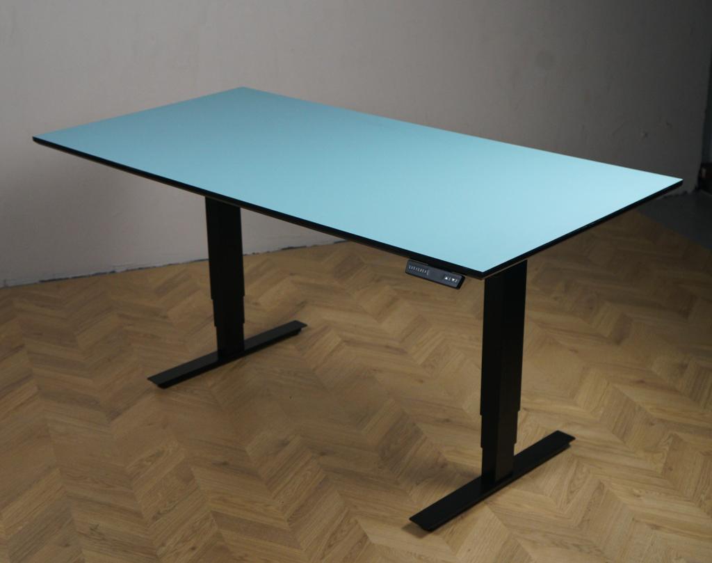 Arnehus hæve-sænkebord med lyseblå linoleum bordplade og mørkeblå stel set i skrå vinkel. Elektrisk justerbart skrivebord i størrelse 160x80 cm med moderne ergonomisk design.